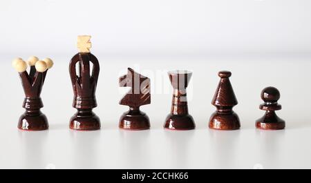 All six black chess pieces in a row on white background Stock Photo