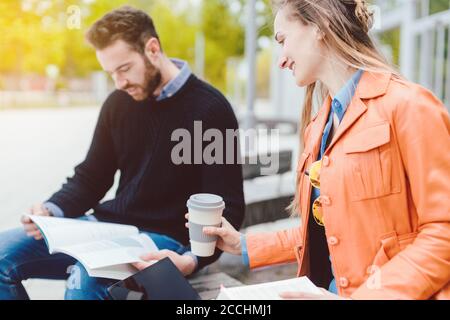 Students learning and reading together on college campus Stock Photo