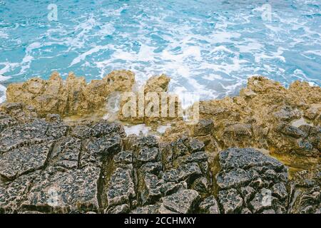 Dangerous rocky sea shore with azure water, aerial drone top view. Stock Photo