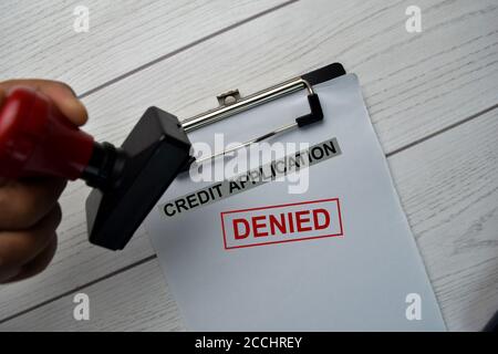 Red Handle Rubber Stamper and Credit Application - Denied text isolated on the table. Stock Photo