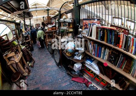 London, United Kingdom - April 01, 2007: Extreme wide angle - fisheye - photo. Stalls with various used stuff, mostly books, shoppers in background at Stock Photo