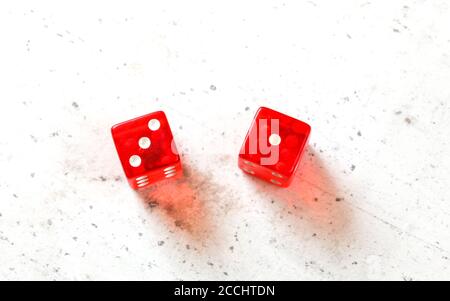 Two red craps dices showing Easy Four (number 3 and 1) overhead shot on white board Stock Photo
