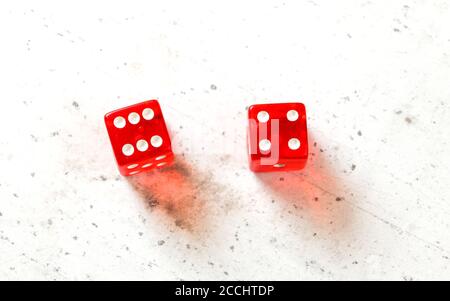Two red craps dices showing Easy Ten (number 6 and 4) overhead shot on white board Stock Photo