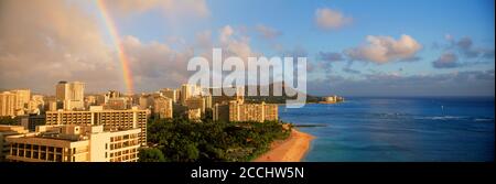 Rainbow over Waikiki with  Diamond Head and beach front hotels with palm trees on Oahu Island in Hawaii Stock Photo