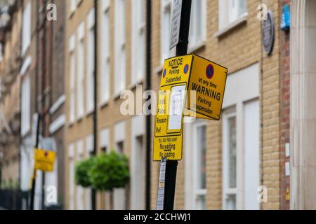 Closeup of yellow car parking suspension sign restricting car parking in Essex Street, London, UK with copy space Stock Photo