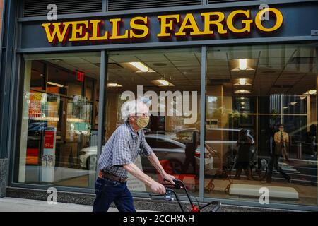 New York, NY, USA. 21st Aug, 2020. A man wearing a face mask passes by a Well Fargo branch in Midtown area of New York City. Wells Fargo resumes job cuts after pandemic break, report says. Credit: John Nacion/SOPA Images/ZUMA Wire/Alamy Live News Stock Photo