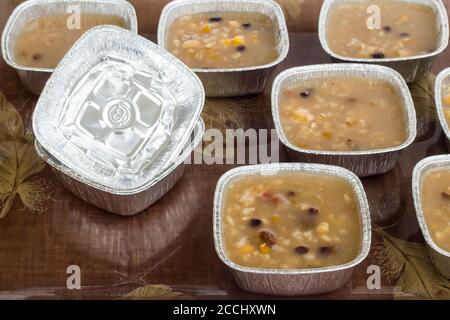 Traditional Turkish Dessert Asure on tray with ladle and aluminum bowls,foil containers.Take away food. Stock Photo