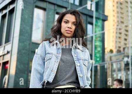 Beautiful young African woman looking at camera on city street, portrait. Stock Photo