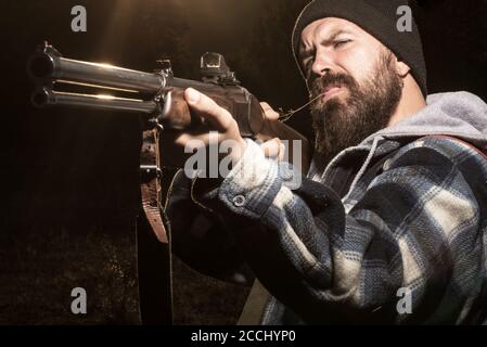 Shooter sighting in the target. Hunter man on the hunt. Hunting rifle. Male with a gun. Hunterman with hunting gun and hunting form to hunt. Barrel of Stock Photo