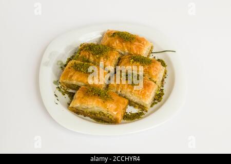 Traditional Turkish Pastry Dessert,Pistachio Baklava in plate at white surface with copy space Stock Photo