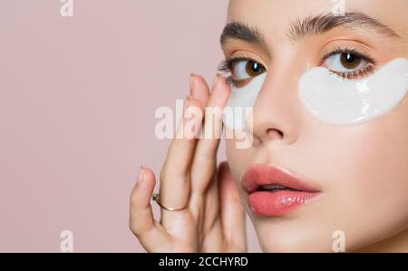 Beauty girl face with flakes under the eyes, closeup. Young womans flakes. Patches under close eyes for woman. Patches under eyes from wrinkles. Stock Photo