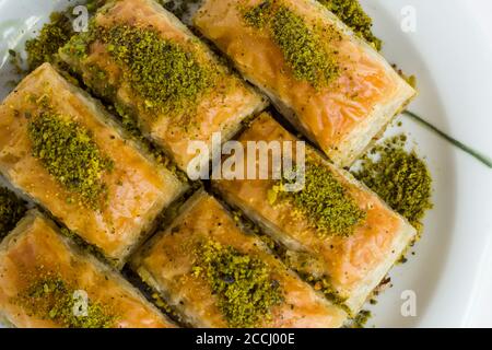 Traditional Turkish Pastry Dessert,Pistachio Baklava in plate at white surface with copy space Stock Photo