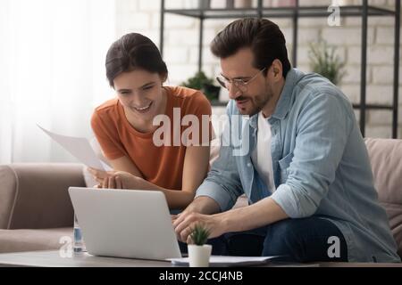 Millennial couple pay bills online on laptop Stock Photo