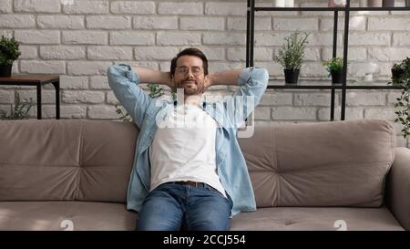 Young caucasian man relax on sofa taking nap Stock Photo