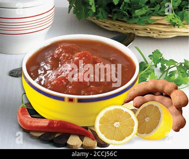 Tamarind with tamarind water concentrate chutney pulp or paste on white background, Red Chatani, coriander , chilli, basil, mint and tomato mixed sauc Stock Photo