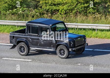 2006 black Land Rover Defender 110 TD5 XS Dblcb; Vehicular traffic moving vehicles, cars driving vehicle on UK roads, motors, motoring on the M6 motorway highway network. Stock Photo