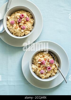 Quinoa porrige on tabletop. Two bowl wit quinoa milk porridge with berries and almond. Top view or flat lay. Vertical. Stock Photo