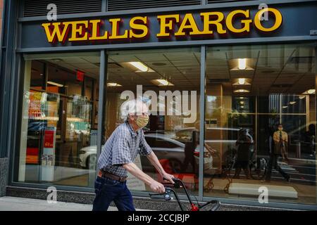 New York, United States. 21st Aug, 2020. A man wearing a face mask passes by a Wells Fargo branch in Midtown area of New York City. Credit: SOPA Images Limited/Alamy Live News Stock Photo