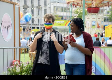 Unusual couple, one wearing a rainbow face mask Stock Photo