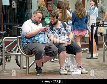 Two obese men in conversation on a bench Stock Photo