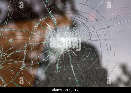 broken glass. Car glass cracked from an accident. Armored glass after impact. glass reinforced with a film after being hit by a bullet. Stock Photo