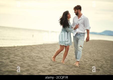 Young lovers in romantic moments on the beach on a beautiful weather Stock Photo