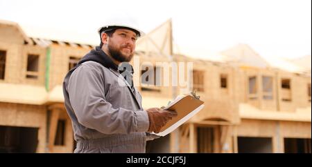Banner of architect drawing plan in notebook at construction site. Stock Photo