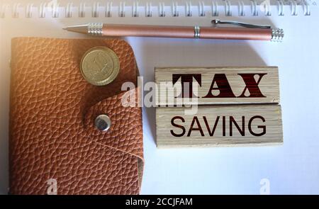 TAX saving words on wood blocks, wallet, coins. Business concept Stock Photo