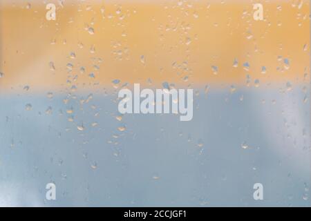 Water rain drops or condensation over blurred orange and blue background. Easy to put over any background. Stock Photo