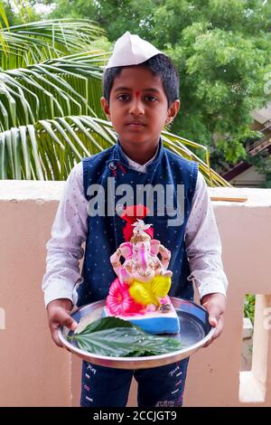 Kalaburagi, Karnataka/India-August 22.2020: boy bringing colorful idol Ganesha to home for Ganesha chaturthi Stock Photo