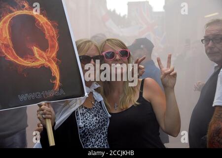 Two women with Q fire poster, during Right Wing protest, in Nottingham Stock Photo