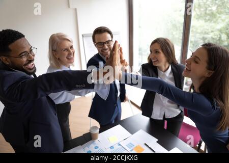 Excited diverse managers teammates giving high five Stock Photo
