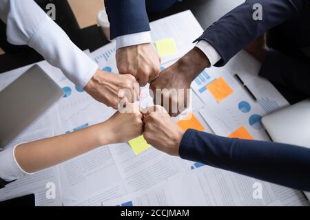 Group of diverse businesspeople teammates demonstrating partnership joining fists together Stock Photo