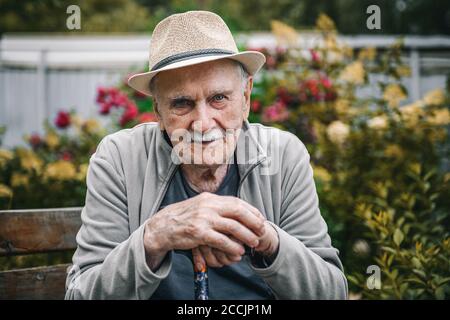 Portrait of a smiling and confident older 87-year-old handsome man in a hat with a mustache. Happy active old age. Portrait of a man in the autumn Stock Photo