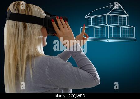 Young girl getting experience using VR headset glasses, creates a project of the house, being in a virtual reality Stock Photo