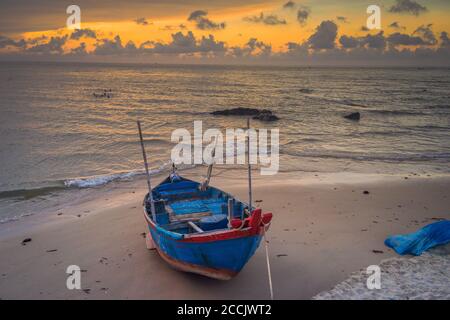 Old fisherman tradition wooden boat at sunrise time on the Bai Sau beach, Vung Tau, Vietnam. Concept Fisherman's life style Stock Photo