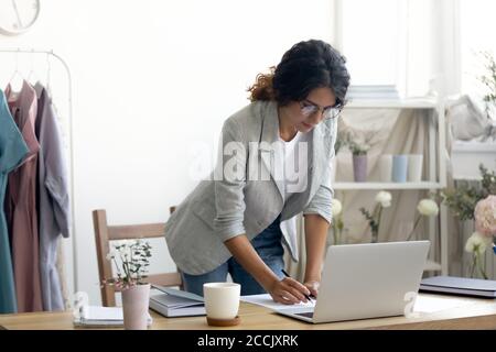 Focused young designer working standing at table. Stock Photo