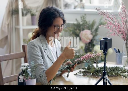 Smiling beautiful young professional decorator showing thumbs up gesture. Stock Photo
