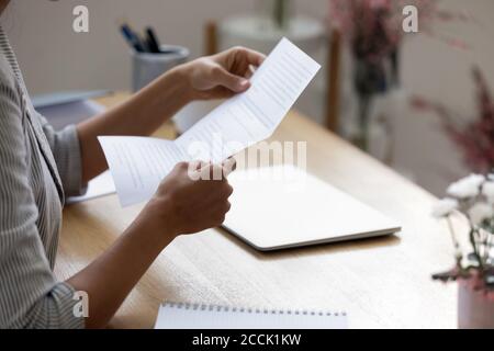 Close up young woman holding paper letter with good news.