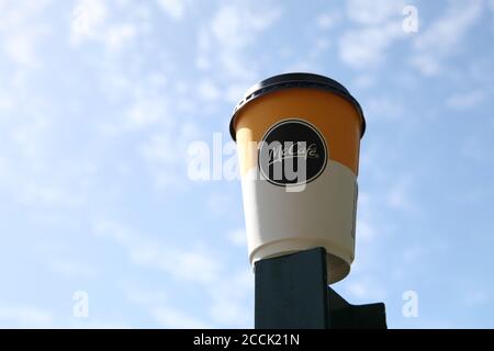 McDonald's McCafe disposable coffee cup on blue sky background, looking up, 2020 Stock Photo