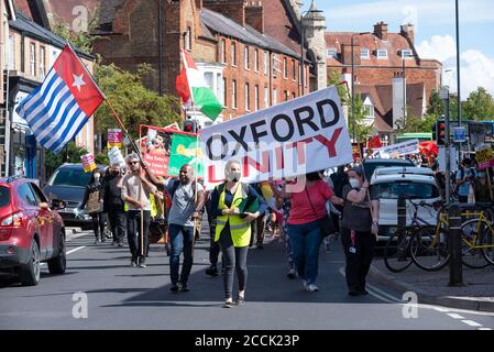 Oxford, UK. 22nd August 2020. A vibrant broad coalition of 13 local community groups supporting the Oxford Unity March gathered on Manzil Way Green before marching to the City Centre. Protesters carrying placards and banners chanted slogans relating to climate change, black lives matter, decolonise, decarbonise, no justice no peace, no covid evictions and more. The marchers stopped for speeches at Oriel College and the Town Hall while on route to a rally at Bonn Square. The well supported march was trouble free. Pictured, Cowley Road, head of the march. Credit: Stephen Bell/Alamy Stock Photo