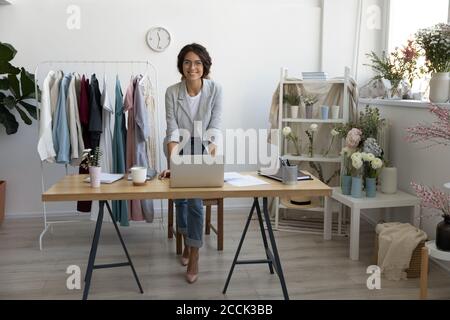 Portrait of attractive smiling young stylish fashion clothes designer. Stock Photo