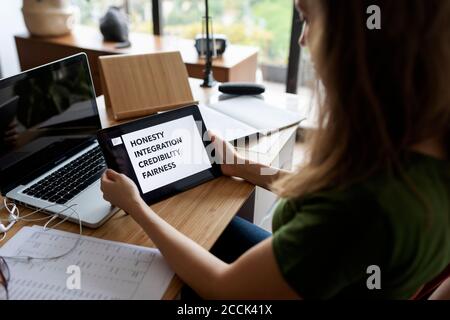 Close-up of businesswoman using digital tablet on desk in home office Stock Photo