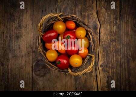Tomatoes in a wicker basket on a branch Stock Photo - Alamy