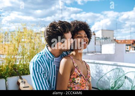 Happy multi-ethnic couple spending quality time on penthouse patio Stock Photo