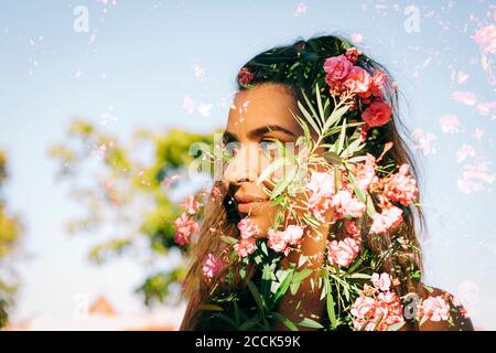 Double exposure of thoughtful young woman and flowers against clear sky Stock Photo