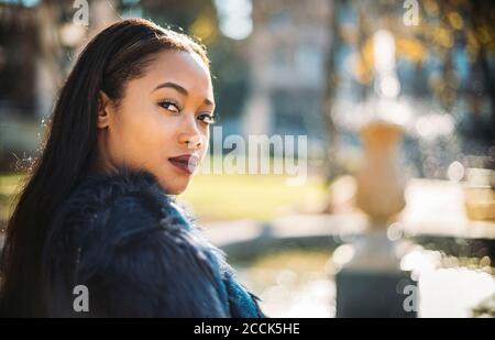 Young woman looking over shoulder outdoors Stock Photo