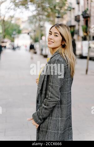 Young woman looking at camera in city