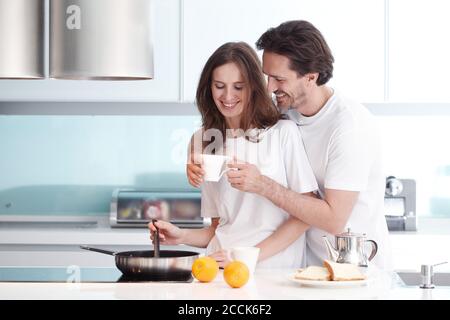 Happy couple cooking breakfast together in the kitchen Stock Photo