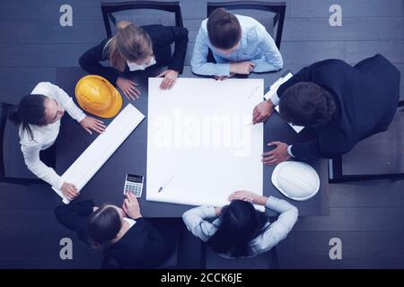 Top view of people around table in construction business meeting Stock Photo